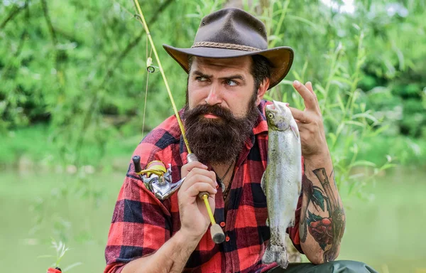 Forel vangst. sportieve activiteiten en hobby. ervaren visser in bos. Succesvolle visserij. zomer weekend. man met grote vis vangst. volwassen man ontspannen na het vissen. visser op Camping — Stockfoto