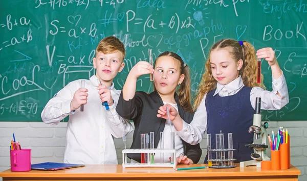 結果を確認します。女の子と男の子学生行動実験の液体。チームワークの概念。カラフルな液体物質テスト チューブ。液体の状態の研究。グループの児童研究化学液体 — ストック写真