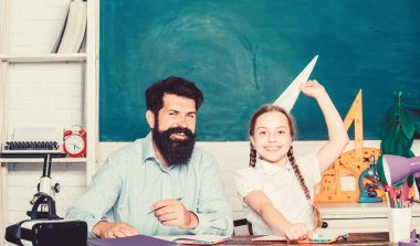 İşe odaklanmak. Okula geri dön. Özel öğretmenlik. sınıfta sakallı öğretmen adam ile küçük kız çocuk. bilgi günü. Evde eğitim. özel ders. baba ile kızı çalışma. Öğretmenler günü
