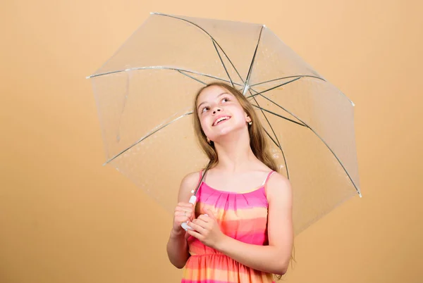 Regnigt väder. Höststämning. liten flicka med paraply. bekymmerslös barndom. höstvädret prognos. höstens mode. barn med trabsparent parasoll. Trendig skönhet — Stockfoto