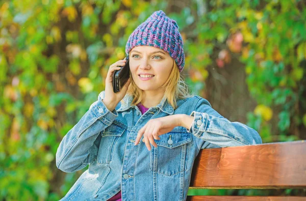 Flickan har rörlig telefonerna konversation i park. koppla av på bänken i srpring. väntar på pojkvän. Dela glada nyheter med vän. kvinna i bra humör idag. trevligt prat. Hipster kvinna talar på telefon — Stockfoto