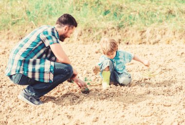 küçük çocuk çocuk tarım baba yardım. yeni bir hayat. toprak ve gübre. mutlu dünya günü. Çevrenin destekçisi. baba ve oğul toprağa çiçek ekiyor. zengin doğal toprak. Eko çiftlik. toprak gün