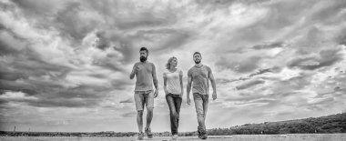 United group purposefully moves forward. Friendship tested for years. Men and woman walks dramatic cloudy sky background. True friendship grow with destiny obstacles. United threesome true friends clipart