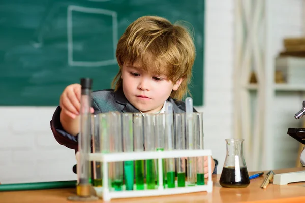 Kid studie chemie. Biotechnologie en farmacie. Geniale leerling. Chemische analyse. Science concept. Wunderkind experimenteren met chemie. Jongen test buizen kleurrijke vloeistoffen chemie school klas — Stockfoto