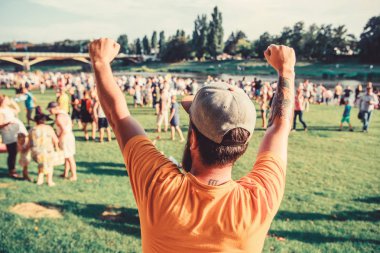 Başarının sırrı ilerlemeye devam etmektir. Başarılı olmak için kazanan jest yapan hevesli adam. Hipster yaz manzarasında başarıyı kutluyor. Sakallı adam başarı için heyecanlı