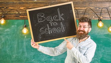 Gözlük öğretmen okul için başlıklı yazı tahtası tutar. Öğretmenler kavramı işe. Adam sakal ve bıyık arka plan kara tahta üzerinde mutlu yüz memnuniyetle meslektaşlarım,