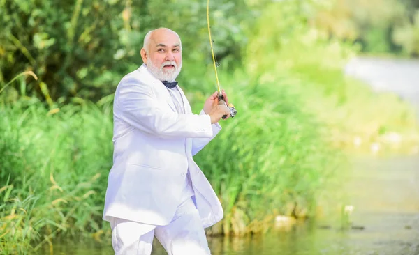 Good profit. hobby and recreation. Fishermen in formal suit. successful catch. business success. mature man fishing. fisher celebrate retirement. good production. retired businessman. Hello Pension