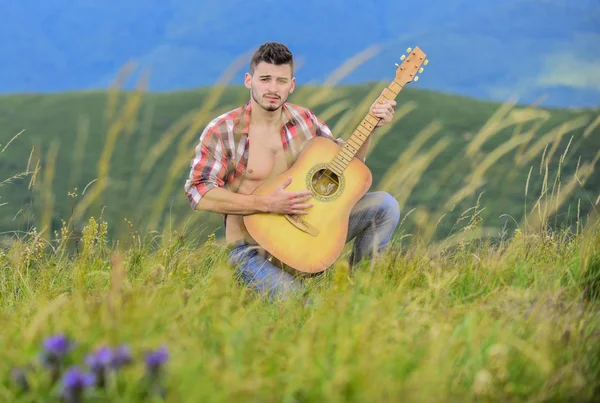 Summer music festival outdoors. Playing music. Sound of freedom. Inspired musician play rock ballad. Compose melody. Inspiring environment. Man with guitar on top of mountain. Acoustic music