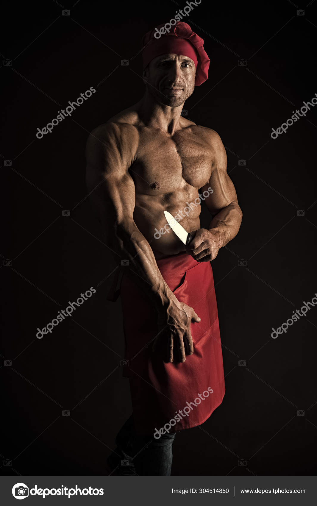 他是个吝啬的厨师。专业厨师在黑色背景。男子做饭与肌肉躯干戴着厨师帽和围裙。首席厨师与六包腹肌拿着菜刀——