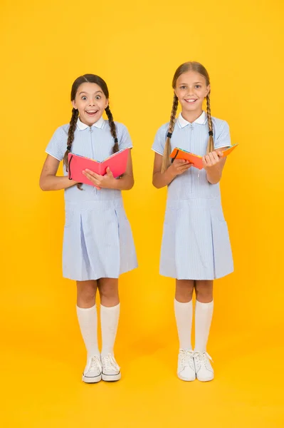 A fazer anotações. meninas pequenas amam literatura. Velha escola. amigos felizes em uniforme retro. moda de criança vintage. de volta à escola. meninas pequenas segurar caderno e bloco de notas. livro de enciclopédia para crianças — Fotografia de Stock