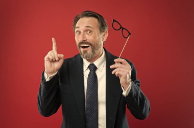 Karnaval katılın. Adam resmi takım elbise giymek sahte gözlük aksesuar. Parti photo booth sahne neşeli işadamı. Adam zevk parti karnaval. Tatil Partisi kutlama. Eğleniyor. Kurumsal ofis parti