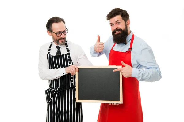 Homens barbudo barman ou cozinheiro em avental segurar quadro branco. Os trabalhadores queriam. Barman com quadro-negro. O empregado de bar do Hipster mostra espaço para cópias. Homens barbudos hipster a informá-lo. Abertura em breve — Fotografia de Stock