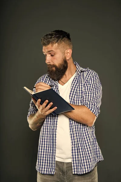 Escribir significa compartir pensamientos e ideas. Hipster escribiendo en cuaderno sobre fondo gris. Hombre barbudo haciendo tareas de escritura. Profesor de escritura creativa —  Fotos de Stock