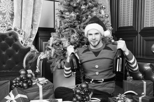 El hombre celebra el año nuevo o la fiesta de Navidad. Concepto de Santa Claus y regalos de Navidad. Hombre usar sombrero de santa ropa elfo celebrar el interior de Navidad abeto decorado y regalos. Navidad tiempo mágico — Foto de Stock