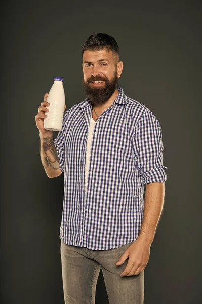 Milch ist großartig für ihre Gesundheit. glücklicher Hipster mit einer Flasche Milch auf grauem Hintergrund. bärtiger Mann, der regelmäßig Milch trinkt. Kaukasier genießen natürliche Kuhmilch — Stockfoto