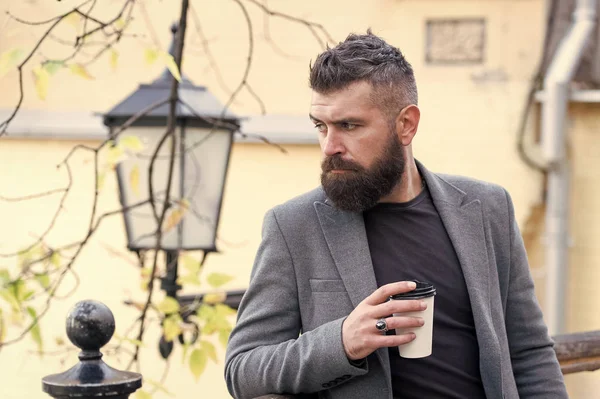 Pause café relaxante. Hipster tenir tasse de café en papier et profiter de l'environnement du parc. Buvez-le en déplacement. Homme barbu hipster préfèrent café à emporter. Homme d'affaires barbu mec boire du café en plein air — Photo