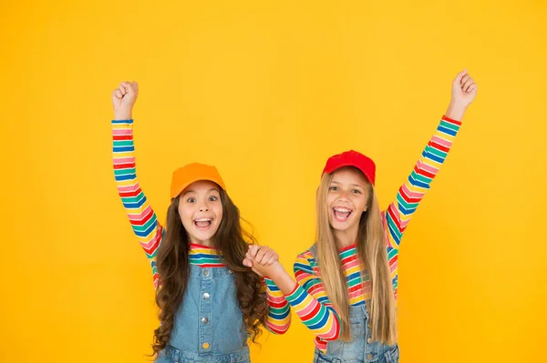 Los ganadores alcanzan su objetivo. Los niños pequeños emocionados haciendo gestos ganadores en el fondo amarillo. Lindos ganadores pequeños disfrutando de la felicidad. Felices ganadores celebrando la victoria o el éxito juntos —  Fotos de Stock