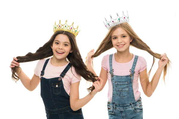 Stoltheten som driver dem. Søte små prinsesser i kroner med lang hårkilde til stolthet. Søte små jenter som er stolte av frisyren sin. Stolthet og glede – stockfoto