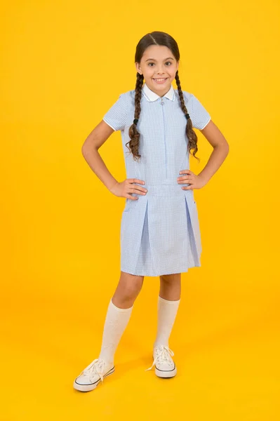 Retro-look. kind in vintage stijl. Old school. Kid mode. gelukkig kind op gele achtergrond. mode en schoonheid. jeugd geluk. grappig humeur. klein meisje in school uniform. moderne school — Stockfoto