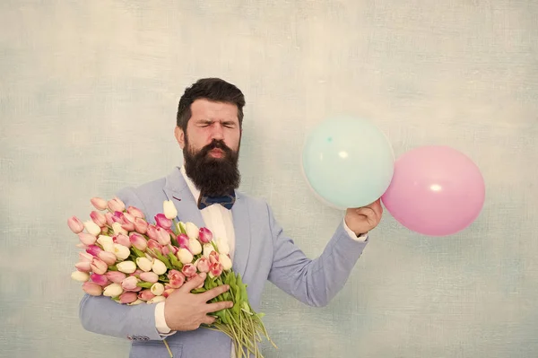 Gentleman making romantic surprise for her. Flowers delivery. Gentleman romantic date. Birthday greetings. For someone special. Man bearded gentleman suit bow tie hold air balloons and bouquet — Stock Photo, Image