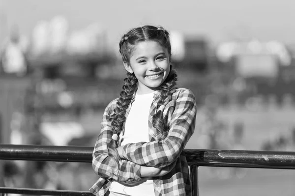 Opciones de ocio. Tiempo libre y ocio. Chica lindo niño con trenzas relajante fondo urbano desenfocado. Organizar actividades para adolescentes. Vacaciones y ocio. ¿Qué hacer en vacaciones. Día soleado a pie — Foto de Stock