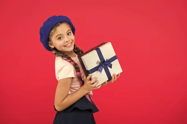 Zgadywać co Twoje marzenie dziecka. Najlepsze zabawki i prezenty świąteczne. Dziecko dziewczynka w beret kapelusz trzymać pudełko. Dziecko podekscytowany rozpakowanie prezent. Małe słodkie dziewczyny otrzymały gift pack z wstążka łuk — Zdjęcie stockowe