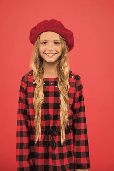 Comment porter un béret comme une fille de la mode. Enfant petite fille mignonne avec les cheveux longs posant dans le chapeau fond rouge. Comment porter un béret français. Inspiration de style béret. Accessoire de béret à la mode pour femme — Photo