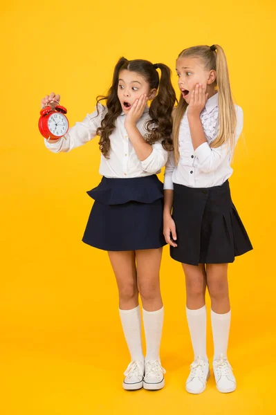 Timing is tijd studie. Beklemtoonde kleine kinderen kijken naar klok met timing signaal op gele achtergrond. Kleine meisjes in paniek houden Vintage timing apparaat. Deadline timing — Stockfoto