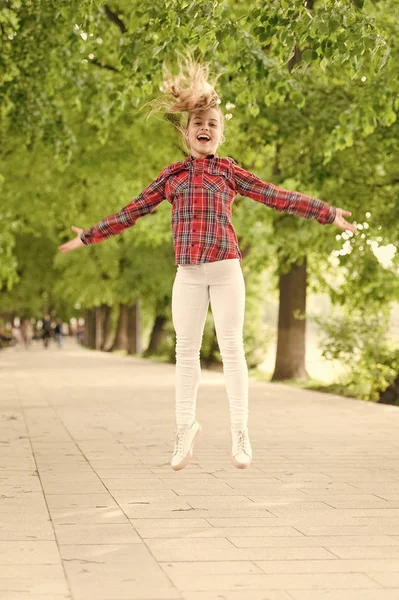 Frisk luft ger henne vital energi. Hög energi eller hyperaktiv Kid. Liten flicka hoppar i avslappnad passform för energisk aktivitet. Energikoncept. Hälsosam livsstil ger barnet energi — Stockfoto