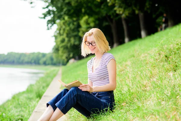 La chica se sienta en la hierba verde cerca del río. Chica relajándose a orillas del río después del día de trabajo. Mujer soñando con vacaciones. Descansa relajado y pasatiempo. Pase tiempo libre para usted. Temporada de vacaciones. Vacaciones de verano —  Fotos de Stock