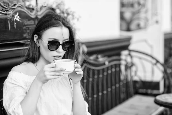 Gadis menikmati kopi pagi. Wanita berkacamata hitam minum kopi di luar ruangan. Gadis santai di cafe cappuccino cup. Dosis kafein. Kopi untuk hari yang sukses. Menunggu tanggal. Sarapan waktu di kafe — Stok Foto
