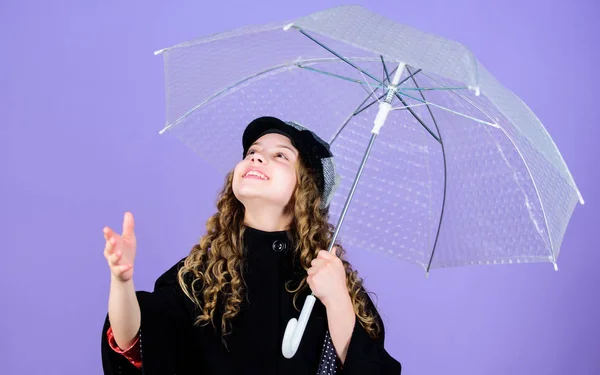 Moda autunno. Ragazzina con berretto e cappotto francese. protezione contro la pioggia. Arcobaleno. allegro bambino hipster di umore positivo. bambina felice con ombrello trasparente. Godersi la giornata autunnale — Foto Stock