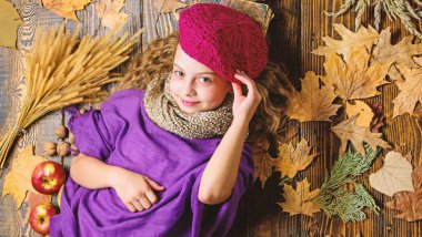 Çocuk kız moda giyim örme şapka bere ve atkı. Sonbahar moda aksesuarları kavramı. Moda trend sonbahar sezonu. Çocuk yatıyordu ahşap arka plan yaprakları yukarıdan düşmüş. Aksesuar moda ayrıntı örme