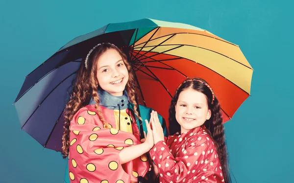 Protección contra la lluvia. Arco iris. moda de otoño. niñas felices con paraguas colorido. niños hipster alegres, hermandad. lazos familiares. Niñas con impermeable. Cualquier clima es bueno —  Fotos de Stock