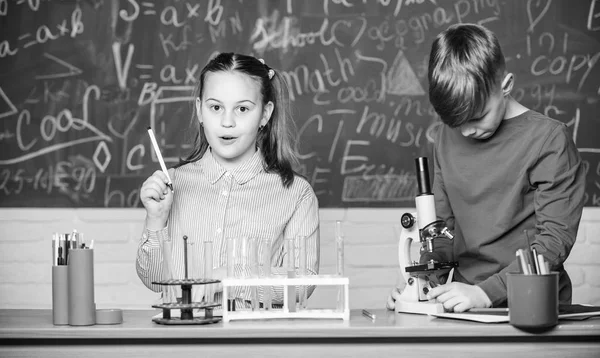 Educación escolar. Análisis químico. Los niños estudian química. Lección de química escolar. Laboratorio escolar. Chica y niño se comunican mientras realizan el experimento escolar. Niños estudiando juntos en clase —  Fotos de Stock