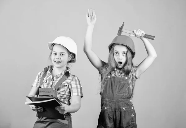 Little kids in helmet with tablet and hammer. Labor day. 1 may. small girls repairing together in workshop. Foreman small girls inspector. Repair. happy children. Future career. small girls — Stock Photo, Image