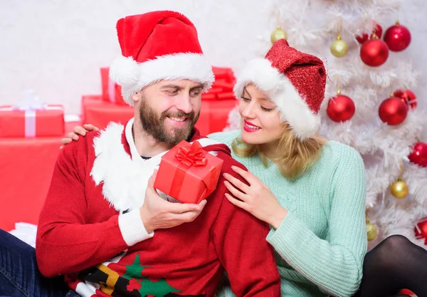 Milující dvojice s úsměvem při vybalování dárků s vánočním stromkem. Milenci si užijí vánoční svátky. Rodina připravila vánoční dárky. Vánoce jsou čas dát — Stock fotografie