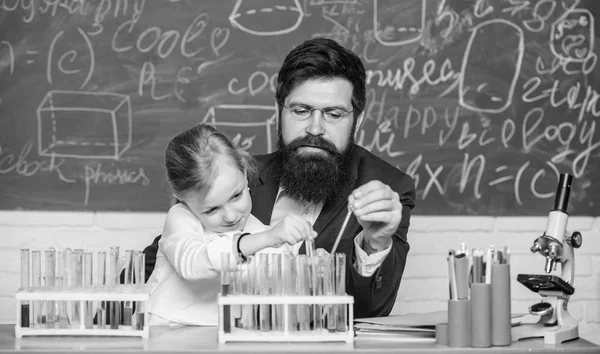 Fascinating chemistry lesson. Man bearded teacher and pupil with test tubes in classroom. Private lesson. School chemistry experiment. Explaining chemistry to kid. How to interest children study