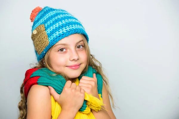 Girl happy face white background. Hat and scarf keep warm. Kid wear warm knitted hat and long scarf. Fall fashion concept. Which fabrics will keep you warmest this autumn. Warm woolen accessories