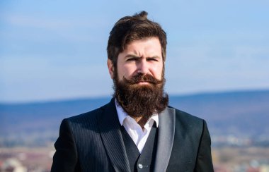 Kalın sakalı hızlı uzat. Adam sakallı hipster resmi takım mavi gökyüzü arka plan giymek. Vintage tarzı uzun sakal. Sakal ve bıyık bakımı. Sakal moda trendi. Şık görünüme yatırım yapın