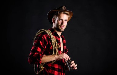 Batı kültürü. Yakışıklı, traşsız, siyah bir kovboy. Batı hayatı. Şapka tutan ip ve matara giyen adam. Amerikan kovboyunun kementi. Şerif kavramı. Vahşi kovboy alkol içiyor.