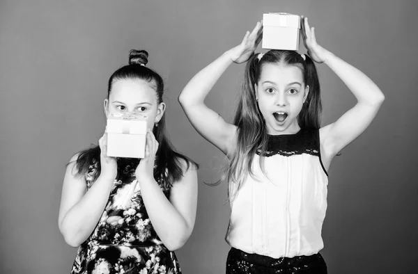 Niños alegres sostienen cajas de regalo. Niños niñas encantado regalo. Las chicas adorables celebran cumpleaños. A los niños les encantan los regalos. Compras y vacaciones. Las hermanas disfrutan los regalos. ¿Qué hay dentro de la caja —  Fotos de Stock