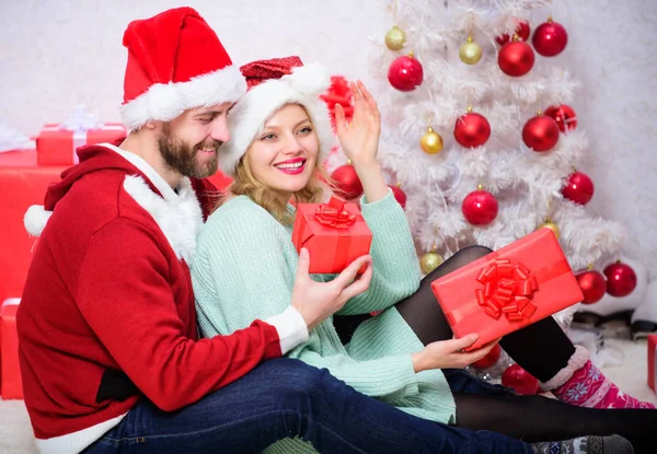 Η οικογένεια ετοίμασε Χριστουγεννιάτικα δώρα. Στοργικό ζευγάρι αγκαλιάζονται χαμογελώντας ενώ ξεπακετάρουν δώρα με φόντο χριστουγεννιάτικο δέντρο. Τα Χριστούγεννα είναι ώρα να δώσεις. Ζευγάρι στην αγάπη Απολαύστε Χριστουγεννιάτικη γιορτή διακοπών — Φωτογραφία Αρχείου
