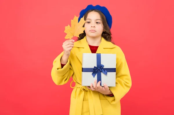 Ημέρα των Ευχαριστιών. Κορίτσι παιδί στα γαλλικά μπερέ κρατήσει δώρο. Φθινοπωρινή αλλαγή. σοβαρό κοριτσάκι με φύλλα σφενδάμου και κουτί. Φθινοπωρινή. Σχολικές πωλήσεις. Φθινοπωρινή παιδική μόδα. Ομορφιά στο στυλ — Φωτογραφία Αρχείου