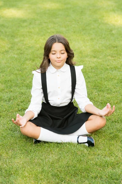 Tune in for productive day. Yoga training. Kid adorable schoolgirl meditate. Meditation practice. Good vibes. Peaceful meditation. Learn meditation techniques. Girl school pupil sit on lawn