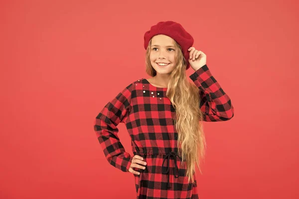 How to wear beret like fashion girl. Kid little cute girl with long hair posing in hat red background. Fashionable beret accessory for female. How to wear french beret. Beret style inspiration