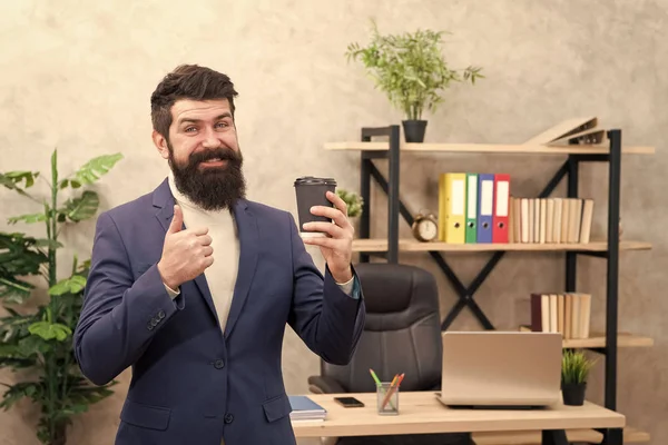 Must have stimulant for him. Man bearded manager businessman entrepreneur hold cup of coffee. Relaxed cheerful top manager drinking coffee. Boss enjoying energy drink. Worker start day with coffee