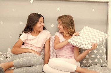 Eğlenmek için akşam vakti. Pijama partisi fikirleri. Kızlar mutlu en iyi arkadaşlar ya da güzel pijamalı kardeşler ve yastıklı pijama partisi. Kız kardeşler pijama partisinde eğleniyor. Yastık savaşı pijama partisi