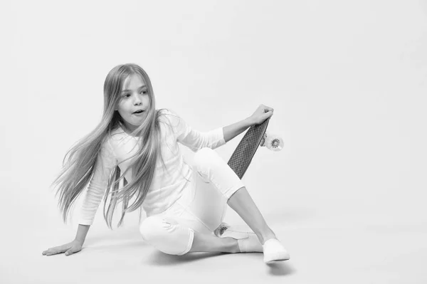 Seeking for extreme freedom and drive. Adorable extreme athlete on pink background. Little girl falling from penny board on extreme speed. Small child enjoying extreme sport and adventure — Stock Photo, Image