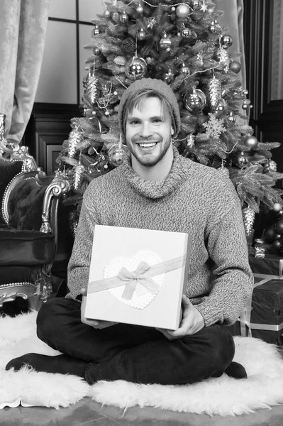 Ο άνθρωπος χαμόγελο με δώρο κουτί κάθονται στο χριστουγεννιάτικο δέντρο — Φωτογραφία Αρχείου